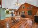 Spacious living room showcasing hardwood floors, wooden walls, and an open layout with kitchen at 2530 Arbuckle Shores Rd, Frostproof, FL 33843