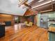 Spacious living room featuring wood floors, exposed beams, spiral staircase and kitchen with stainless steel appliances at 2530 Arbuckle Shores Rd, Frostproof, FL 33843