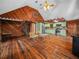 Bright living space with hardwood floors, spiral staircase, wooden walls, and a kitchen view at 2530 Arbuckle Shores Rd, Frostproof, FL 33843