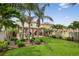 Beautiful backyard featuring a pergola, outdoor kitchen, well-manicured lawn, and mature palm trees at 2612 San Simeon Way, Kissimmee, FL 34741