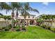 Beautiful backyard featuring a pergola, outdoor kitchen, well-manicured lawn, and mature palm trees at 2612 San Simeon Way, Kissimmee, FL 34741