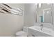 Modern half bathroom featuring sleek fixtures, a stylish mirror, and contemporary decor with bright accents at 2612 San Simeon Way, Kissimmee, FL 34741