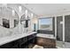 Well-lit bathroom with double sinks, a soaking tub, a walk-in shower, and stylish round mirrors at 2612 San Simeon Way, Kissimmee, FL 34741