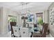 An open dining room features a glass table and plenty of sunlight with a view to an outdoor space at 2612 San Simeon Way, Kissimmee, FL 34741