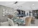 Elegant dining room features a glass table, modern chandelier and kitchen view, perfect for entertaining at 2612 San Simeon Way, Kissimmee, FL 34741
