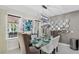 Bright dining room with a glass table, modern chandelier, and decorative mirrors create an elegant space at 2612 San Simeon Way, Kissimmee, FL 34741