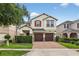 Charming two-story home featuring a brick driveway, well-manicured lawn, and red shutters at 2612 San Simeon Way, Kissimmee, FL 34741