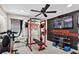 Home gym featuring weightlifting equipment, a television, motivational art, and a ceiling fan at 2612 San Simeon Way, Kissimmee, FL 34741