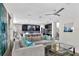 Bright open-concept living room featuring a sleek sofa, stylish decor, and a view into the kitchen area at 2612 San Simeon Way, Kissimmee, FL 34741