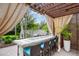 Covered outdoor bar area with counter seating and adjacent grill at 2612 San Simeon Way, Kissimmee, FL 34741