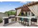 Covered outdoor kitchen featuring an outdoor grill, bar with seating, and outdoor television at 2612 San Simeon Way, Kissimmee, FL 34741