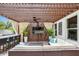 Outdoor covered living space with a bar, seating, ceiling fan, and mounted television at 2612 San Simeon Way, Kissimmee, FL 34741
