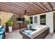Outdoor covered living space with a bar, seating, ceiling fan, and mounted television at 2612 San Simeon Way, Kissimmee, FL 34741