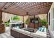 Outdoor covered living space with a bar, seating, ceiling fan, and mounted television at 2612 San Simeon Way, Kissimmee, FL 34741