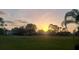 Expansive green space with a backdrop of trees at sunset at 2835 Wingfoot Ct, Winter Haven, FL 33884