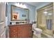 Well-lit bathroom featuring a vanity with dark countertop, framed mirror, and glass shower at 2835 Wingfoot Ct, Winter Haven, FL 33884