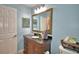 Bright bathroom featuring a vanity, ornate framed mirror, and blue walls at 2835 Wingfoot Ct, Winter Haven, FL 33884