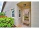 Charming front entrance featuring decorative shrubbery, a secure screen door, and a neutral color scheme for a welcoming feel at 2835 Wingfoot Ct, Winter Haven, FL 33884