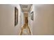 Hallway with wood floors and neutral-colored walls adorned with decorative artwork at 2835 Wingfoot Ct, Winter Haven, FL 33884