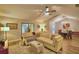 Open concept living room featuring vaulted ceiling, wood-look flooring, and neutral colored sectional with view of dining room at 2835 Wingfoot Ct, Winter Haven, FL 33884