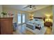 Comfortable main bedroom featuring an upholstered bench, ceiling fan, and access to the outdoors at 2835 Wingfoot Ct, Winter Haven, FL 33884