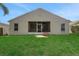 Backyard view of the home showing the screened patio and lush landscaping at 362 Lake Daisy Cir, Winter Haven, FL 33884