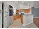 Bright kitchen featuring stainless steel appliances, breakfast bar with granite countertops and wood cabinets at 362 Lake Daisy Cir, Winter Haven, FL 33884