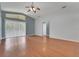 Bright living room with wood floors, a ceiling fan and large glass sliding door with transom window at 362 Lake Daisy Cir, Winter Haven, FL 33884