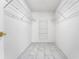 Walk-in closet with a metal shelving system and marble-look tile flooring at 362 Lake Daisy Cir, Winter Haven, FL 33884