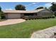 Well-maintained single-story home with a lush green lawn and paved driveway at 381 Troon Ct, Winter Haven, FL 33884