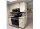 Updated kitchen showcasing stainless steel appliances and classic white cabinetry at 381 Troon Ct, Winter Haven, FL 33884