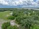 Stunning aerial view of the property surrounded by lush greenery and distant water features under cloudy skies at 3985 Mammoth Grove Rd, Lake Wales, FL 33898