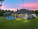 Sunset aerial view of a home featuring an enclosed backyard pool at 3985 Mammoth Grove Rd, Lake Wales, FL 33898