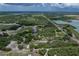 Aerial perspective highlighting the property's location amidst lush landscapes and scenic waterways under a partly cloudy sky at 3985 Mammoth Grove Rd, Lake Wales, FL 33898