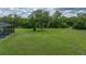 Picturesque backyard boasting ample green space with a large tree, adjacent to a screened pool enclosure at 3985 Mammoth Grove Rd, Lake Wales, FL 33898