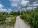 Gravel driveway showing the home with plenty of wooded areas offering privacy at 3985 Mammoth Grove Rd, Lake Wales, FL 33898