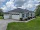 Home exterior with a large garage and front lawn at 3985 Mammoth Grove Rd, Lake Wales, FL 33898