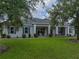 Inviting home exterior with a large front lawn and a covered porch with rocking chairs at 3985 Mammoth Grove Rd, Lake Wales, FL 33898