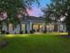 Beautifully lit home showcasing its inviting facade, picturesque landscaping, and welcoming porch in the evening at 3985 Mammoth Grove Rd, Lake Wales, FL 33898