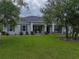 Charming home featuring a well-manicured lawn, inviting porch, and timeless architectural details at 3985 Mammoth Grove Rd, Lake Wales, FL 33898