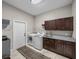 Well-equipped laundry room with washer, dryer, cabinets, granite countertop and sink at 3985 Mammoth Grove Rd, Lake Wales, FL 33898