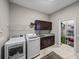 Bright laundry room with modern appliances, storage cabinets, shelves and convenient access to a pantry closet at 3985 Mammoth Grove Rd, Lake Wales, FL 33898