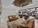 Open-concept living area with kitchen view, elegant furnishings, fireplace, and a coffered ceiling at 3985 Mammoth Grove Rd, Lake Wales, FL 33898