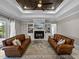 Bright living room with comfortable leather sofas, fireplace, and a decorative ceiling at 3985 Mammoth Grove Rd, Lake Wales, FL 33898