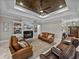Elegant living room featuring dark-wood ceiling, fireplace, leather furniture, and neutral color palette at 3985 Mammoth Grove Rd, Lake Wales, FL 33898