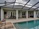 Beautiful covered outdoor pool and patio area with dining set, lounge chairs, and ceiling fans at 3985 Mammoth Grove Rd, Lake Wales, FL 33898