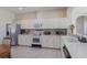 Well-lit kitchen featuring white cabinets, stainless steel appliances, and a breakfast bar at 4338 Dinner Lake Blvd, Lake Wales, FL 33859