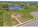 Aerial view of a neighborhood playground, surrounded by green space and a scenic pond at 4338 Dinner Lake Blvd, Lake Wales, FL 33859
