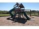 Community playground offering a wooden playset with swings and slides on a sunny day at 4338 Dinner Lake Blvd, Lake Wales, FL 33859