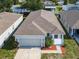 Aerial view of charming single-story home with manicured landscaping and attached two-car garage, red front door at 481 Kensington View Dr, Winter Haven, FL 33880